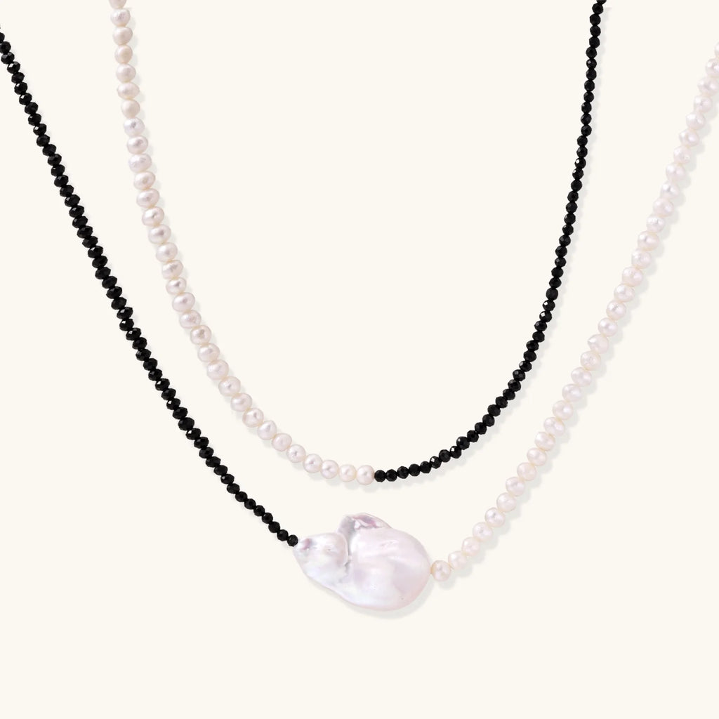 Double-strand necklace with black faceted quartz and white pearls featuring an oversized baroque pearl centerpiece