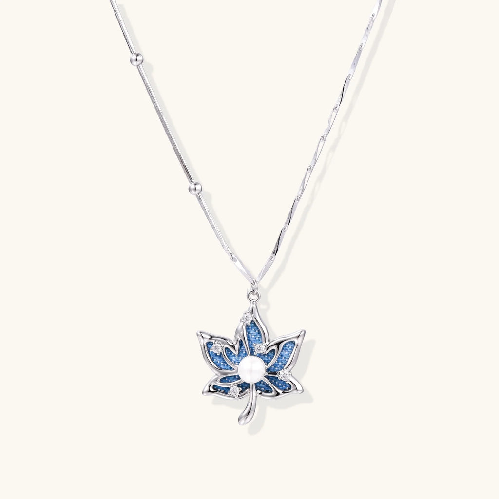 White gold-plated lotus pendant with blue denim fabric inlay and sparkling zirconia stones on adjustable chain