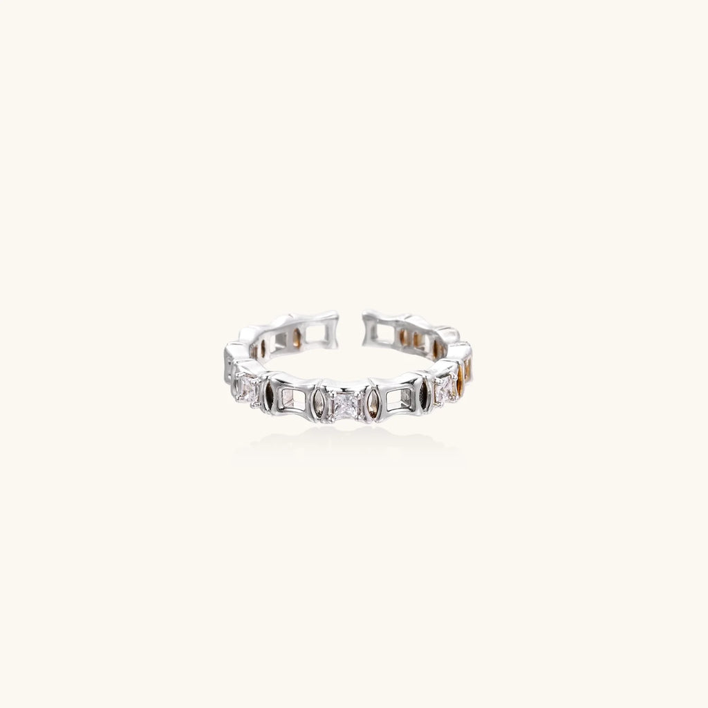 White gold plated ring with architectural lattice design and zirconia accents on cream background