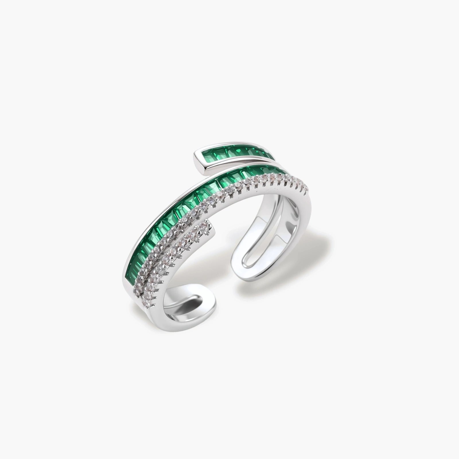 Modern adjustable ring with green baguette stones and clear crystals in parallel bands on white background.
