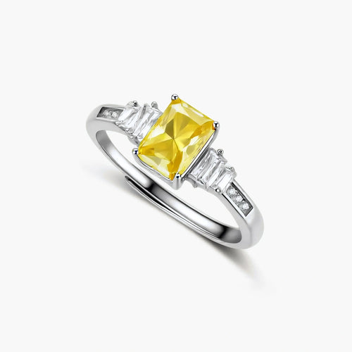 Sterling silver ring with emerald-cut yellow moissanite center stone and clear baguette side stones in elegant setting