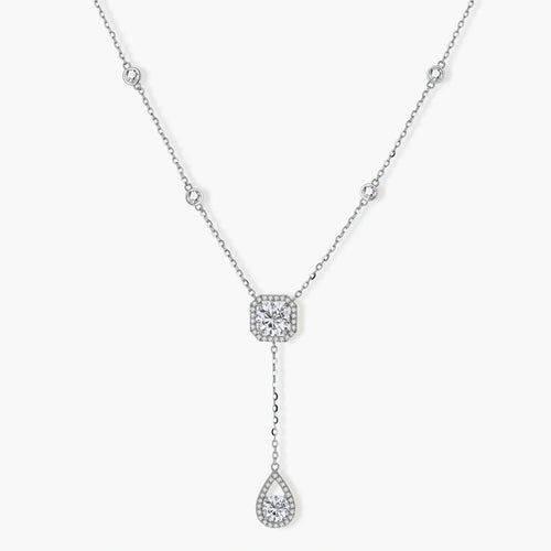 Sterling silver necklace with cushion-cut moissanite in halo setting and teardrop pendant, displayed on cream background.