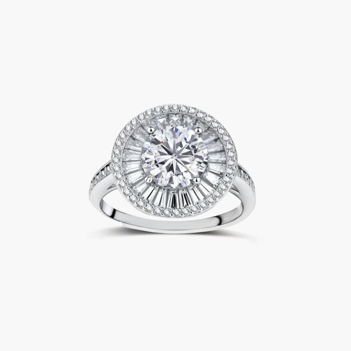 Brilliant round moissanite center stone with baguette and round halo accents in sterling silver setting on light background.