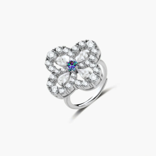Flower-shaped sterling silver ring with brilliant round moissanite center stone and crystal petals on neutral background