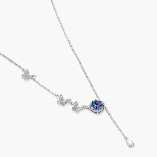 Delicate sterling silver necklace with crystal-set butterfly charms and rainbow moissanite pendant on white background.