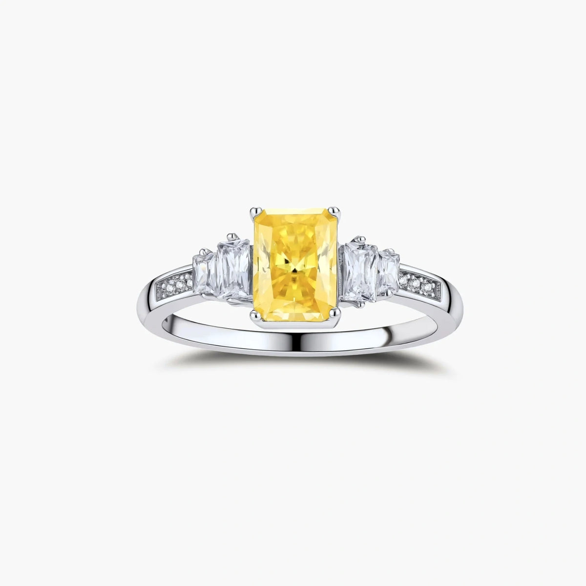 Yellow moissanite jewelry set with emerald-cut stones in sterling silver halo settings on white background.