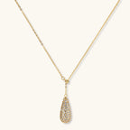 Gold-plated teardrop necklace and earrings covered in AAA cubic zirconia crystals on cream background.