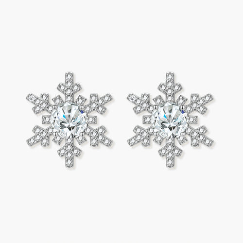 Sterling silver snowflake stud earrings with brilliant moissanite centers and intricate geometric patterns on cream background