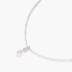 Dainty necklace with lavender crystal beads, freshwater pearls, geometric pendant, and large pearl drop on white background.
