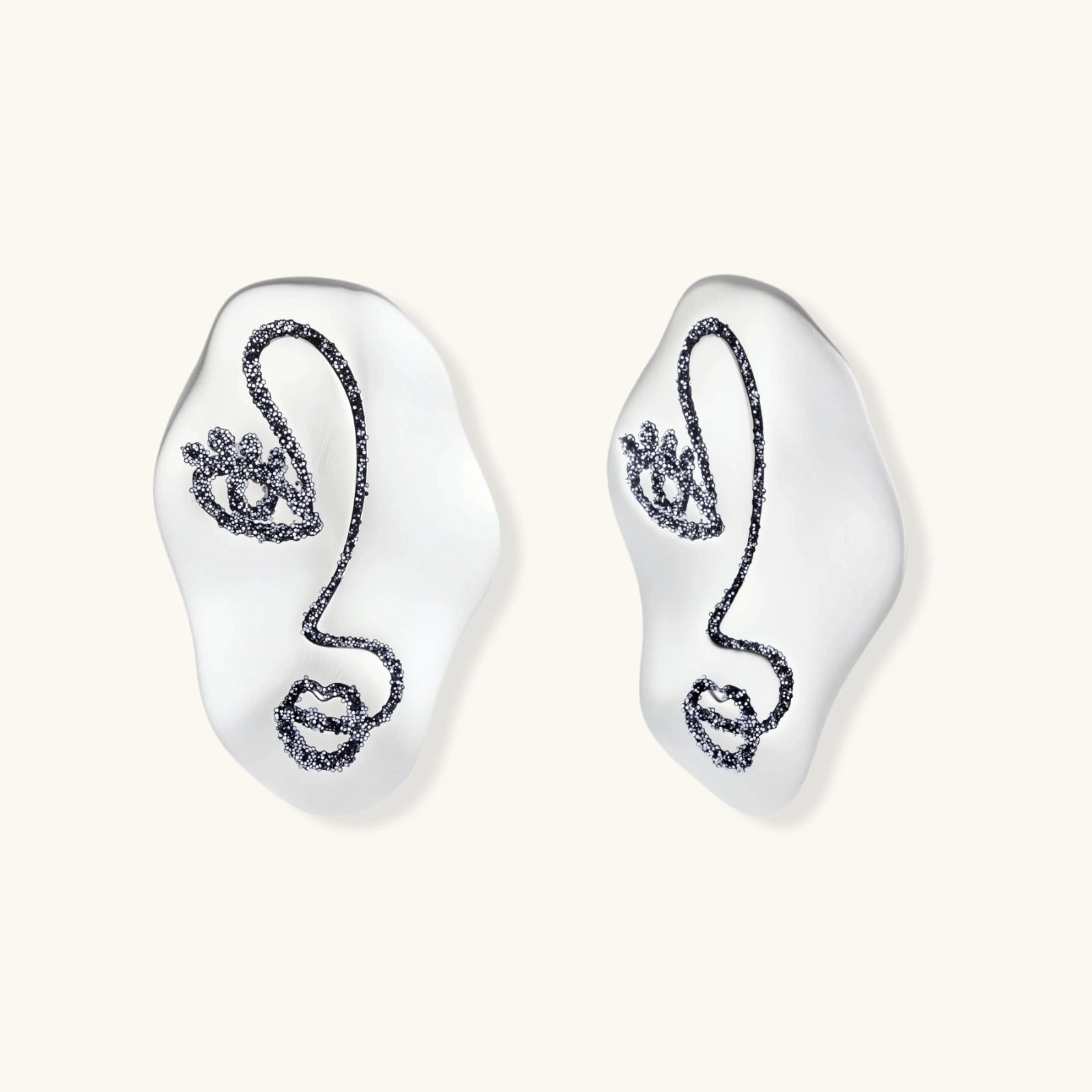 Artistic ear-shaped earrings with minimalist face line art on clear eco-zinc alloy base with sterling silver posts.