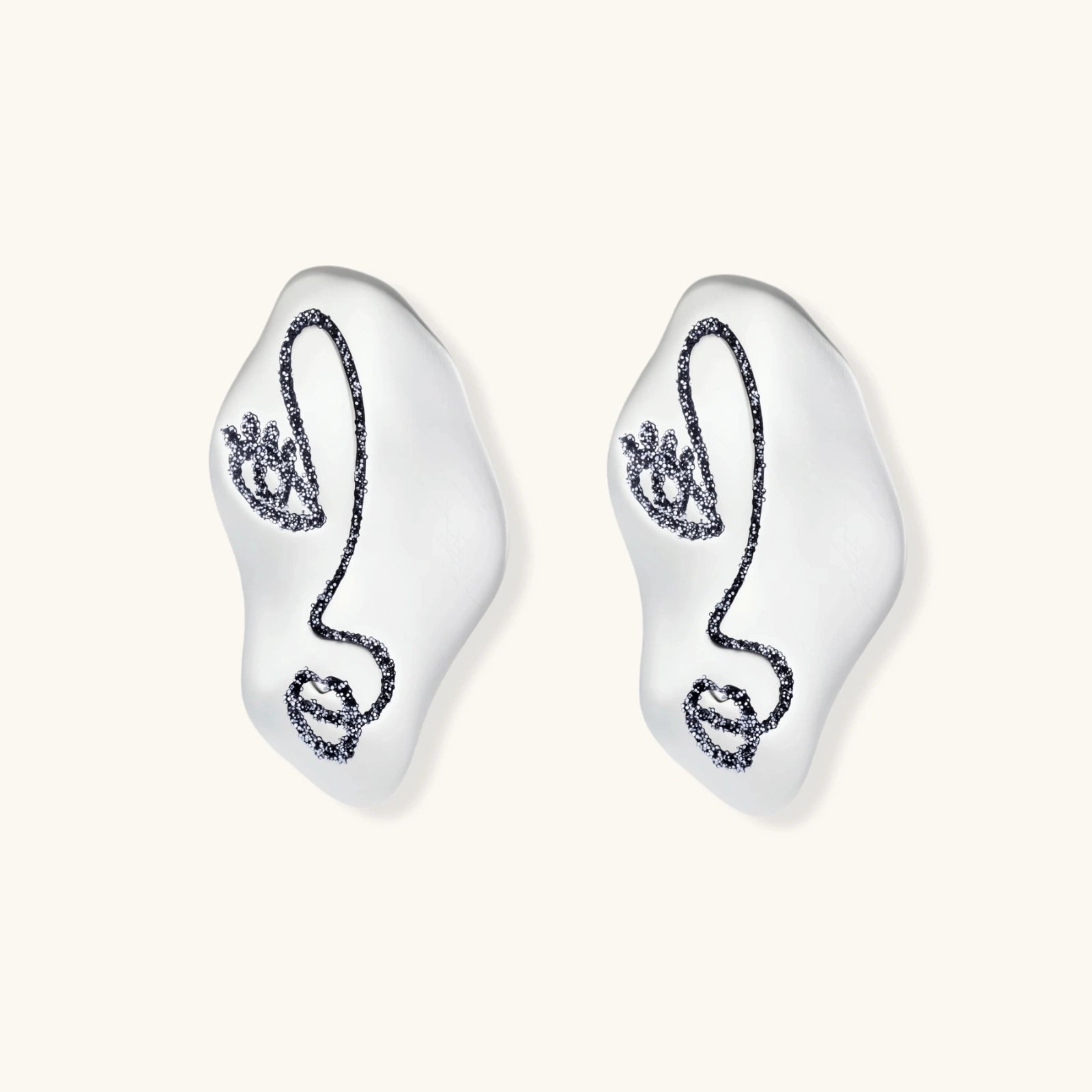 Artistic ear-shaped earrings with minimalist face line art on clear eco-zinc alloy base with sterling silver posts.