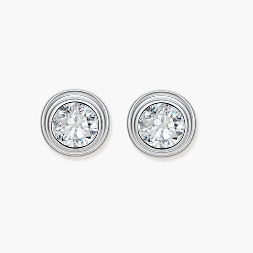 Close-up of sterling silver stud earrings featuring concentric circular frames with brilliant moissanite centers