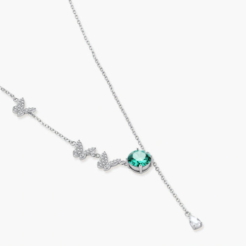 Sterling silver necklace with butterfly charms, green moissanite center stone, and teardrop crystal pendant on white background.