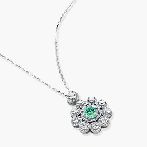 Delicate sterling silver necklace with flower-shaped pendant featuring bright green center moissanite and clear accent stones