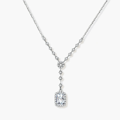 Sterling silver Y-necklace with rectangular moissanite pendant in halo setting and cascading accent stones on white background.
