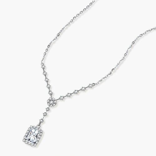 Sterling silver Y-necklace with rectangular moissanite pendant in halo setting and cascading accent stones on white background.