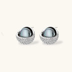 White gold plated spherical jewelry set with zirconia crystal pavé and dark lustrous centers on neutral background.