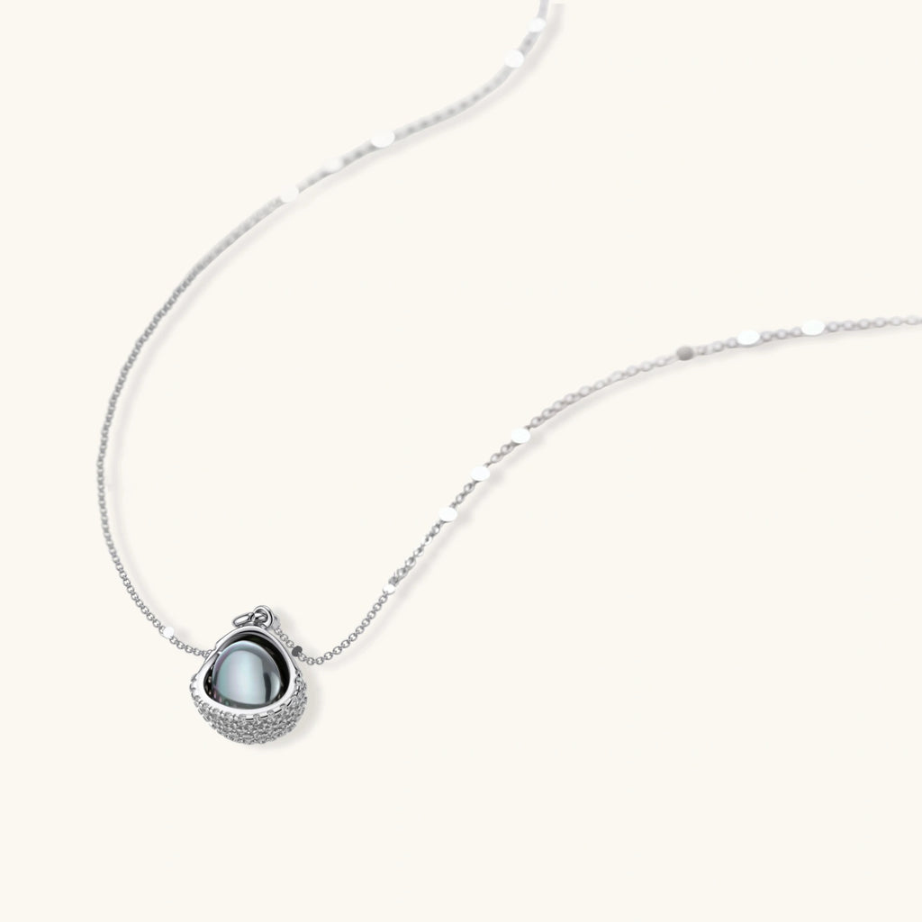White gold plated spherical jewelry set with zirconia crystal pavé and dark lustrous centers on neutral background.